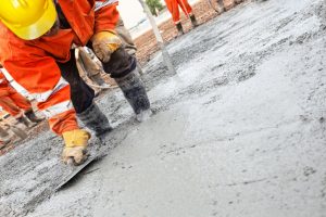 Contractor spreading freshly poured concrete