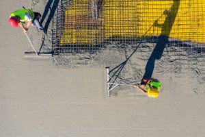 Overhead view of construction workers spreading concrete