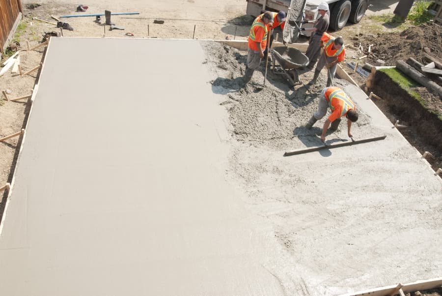 Construction workers leveling concrete