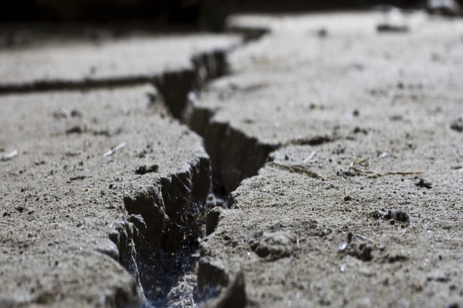 A Close Up of a Large Crack in A Concrete Path